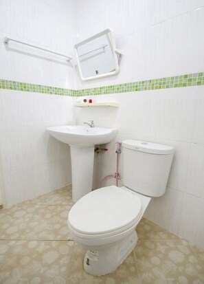 A small bathroom with a toilet, sink, and mirror.