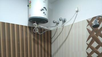 A bathroom with a toilet, a bidet, a shower, and a toilet paper holder.