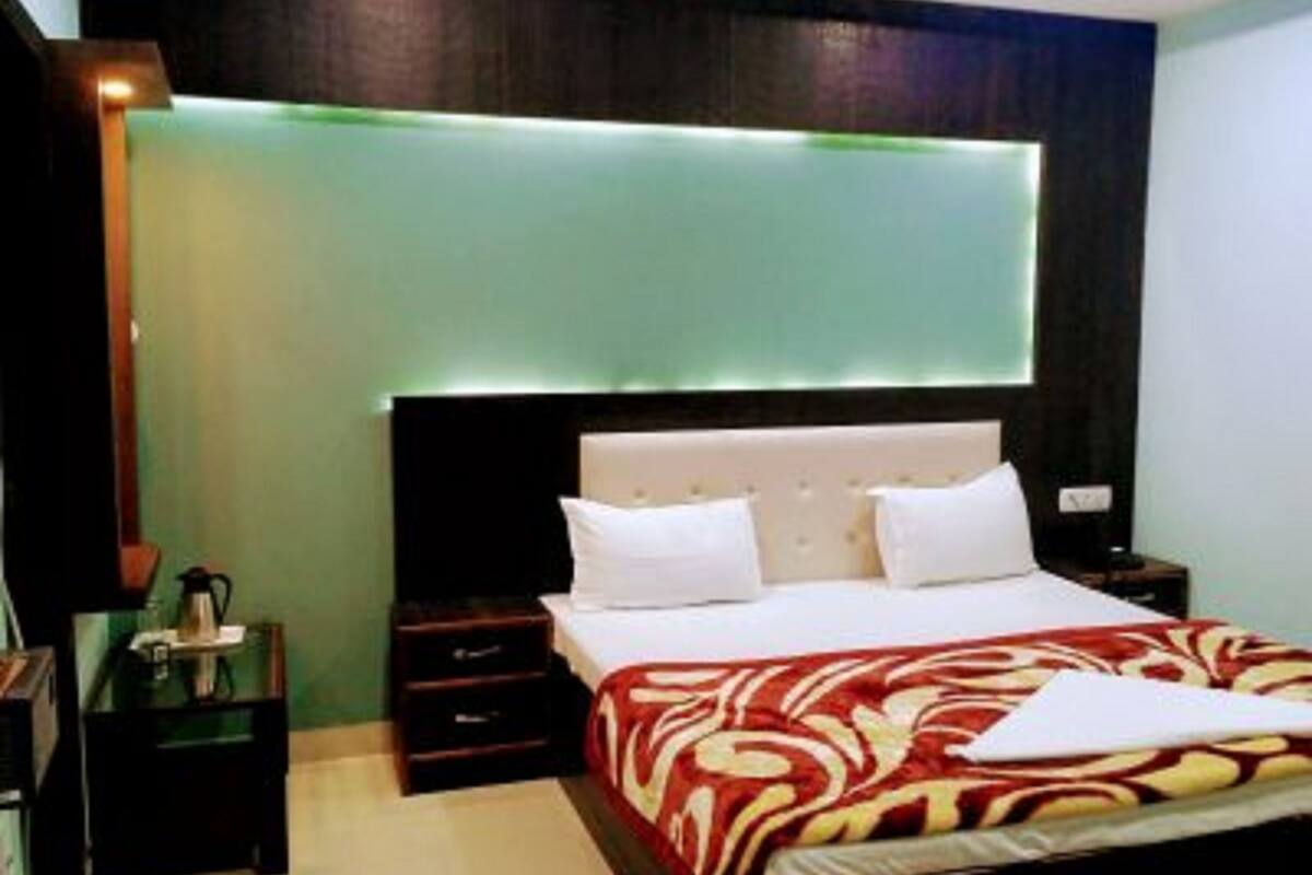 A hotel room with a bed, bedside tables, and a nightstand.