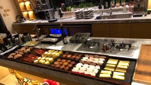 A buffet with various food items and a decorative snowman.
