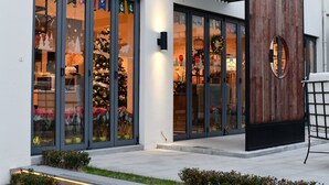 A modern building with large glass windows displaying Christmas decorations.