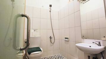 A bathroom with a toilet, a shower, and a sink.