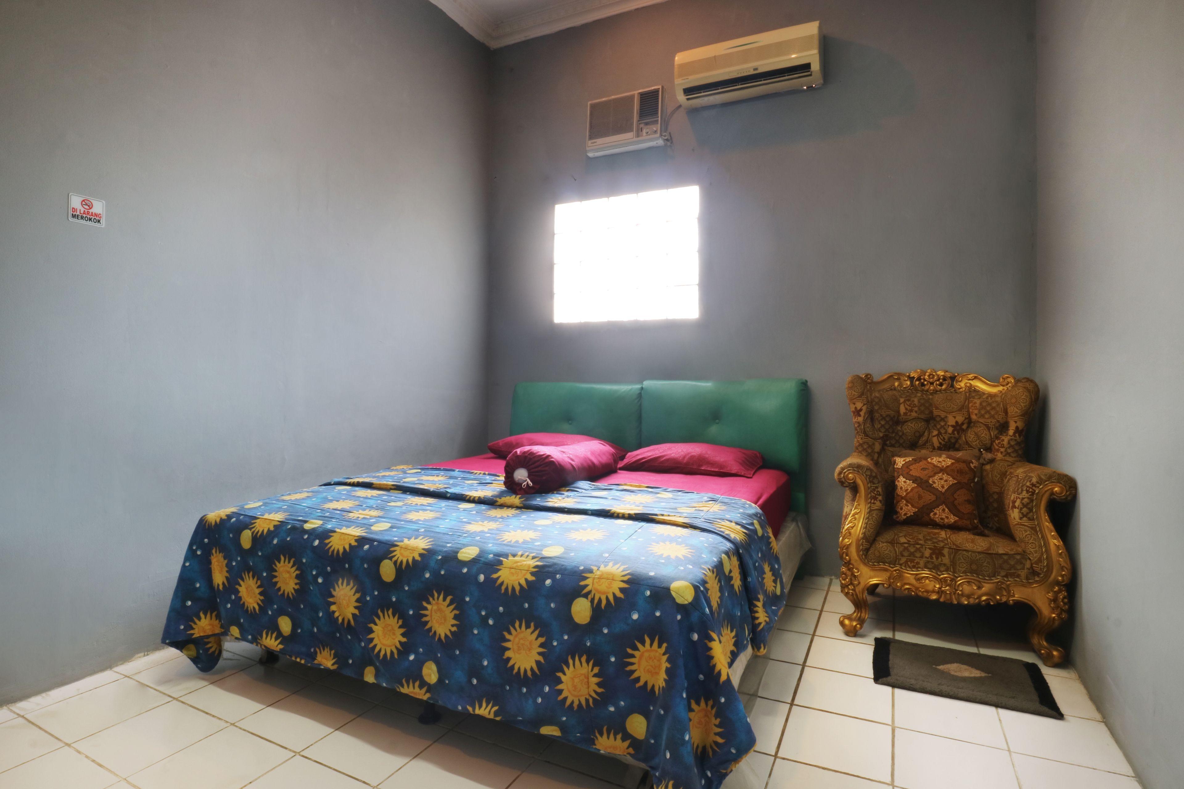 A room with a bed, a chair, and an air conditioning unit.