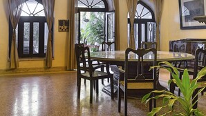 Un comedor con una mesa redonda, sillas, ventiladores de techo, candelabros y adornos de pared con forma de asta de ciervo.