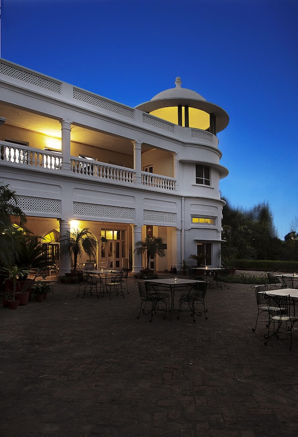 A two-story building with a balcony and outdoor seating area.