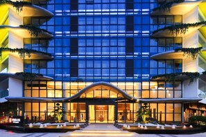 A modern hotel with a symmetrical facade, large windows, and a central entrance with a curved overhang. - Sunforest Resort Hotel (Huangshan)