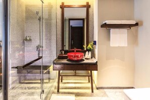 A bathroom with a glass-enclosed shower, a wooden vanity with a red basin, and a mirror above the sink. - Sunforest Resort Hotel (Huangshan)