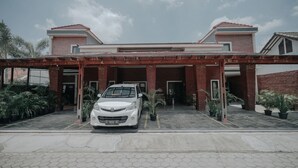 Un bâtiment moderne avec une voiture blanche garée devant.