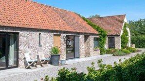 Un bâtiment avec un toit recouvert de tuiles rouges, une façade en briques et une enseigne indiquant « INSTITUUT MAUD ».