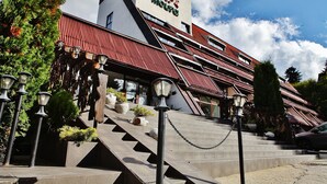 A hotel with a red roof, a sign reading "HOTEL MOURO," and a staircase leading to the entrance. - Hotel Moura (Samokov)