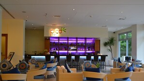 Eine Barbereich mit einem 'pico bar'-Schild, Korbmöbeln und einem großen Fenster.