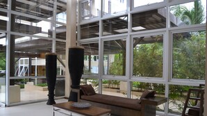 Ein modernes Interieur mit großen Fenstern, einer Couch, einem Couchtisch und einer großen Vase.