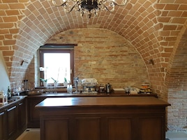 Una cocina con una isla grande, paredes de ladrillo y una ventana con luz natural.