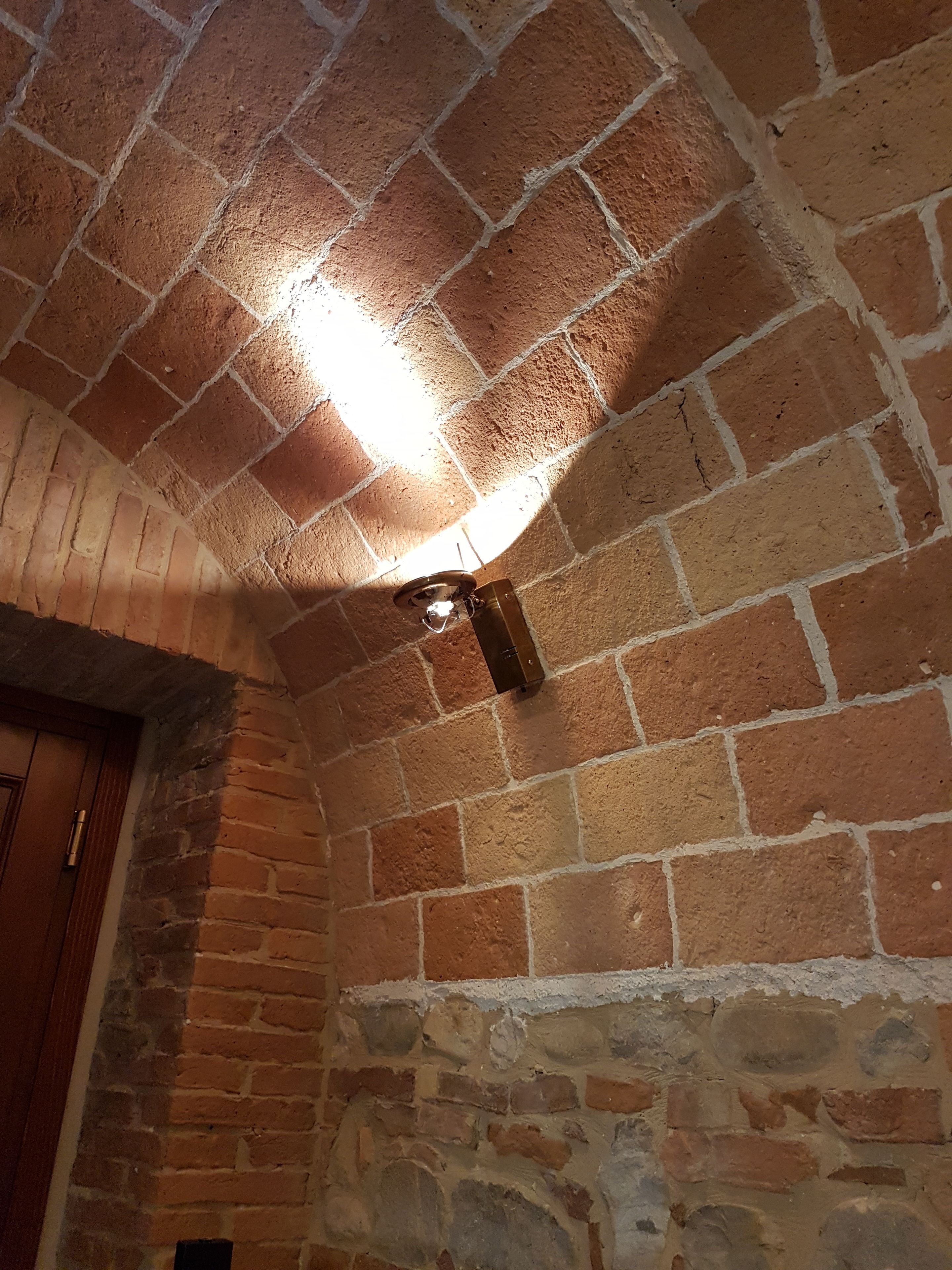 Una habitación con paredes de ladrillo visto y una puerta de madera.