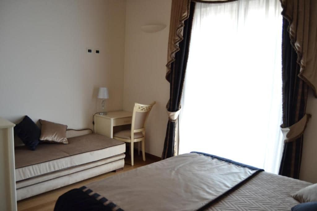 Habitació d'hotel amb llit, sofà, escriptori i cadira.