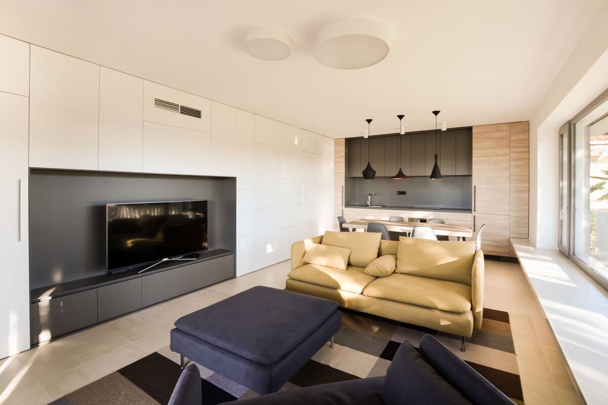 A modern living room with a flat-screen TV, a sofa, and a coffee table.