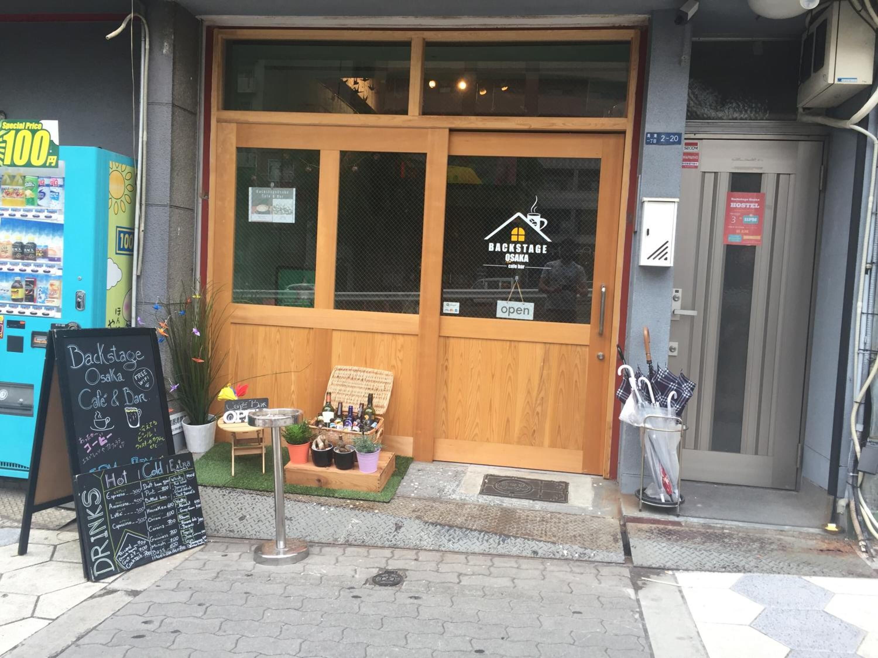 A storefront with a wooden door, a chalkboard menu, and a vending machine.