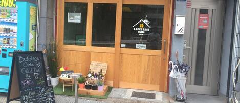 A storefront with a wooden door, a chalkboard menu, and a vending machine.