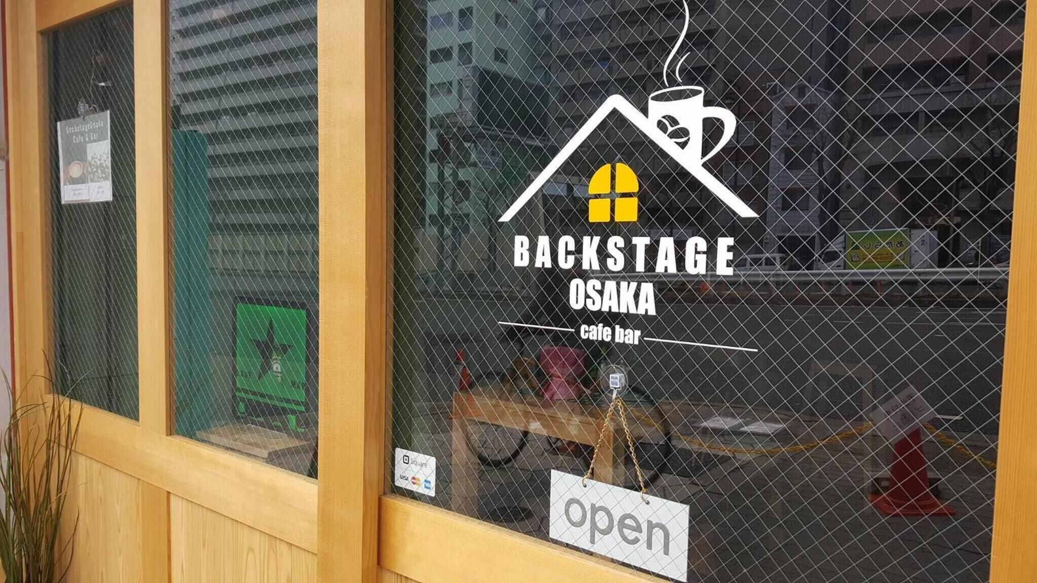 A cafe named Backstage Osaka with a sign indicating it is open.