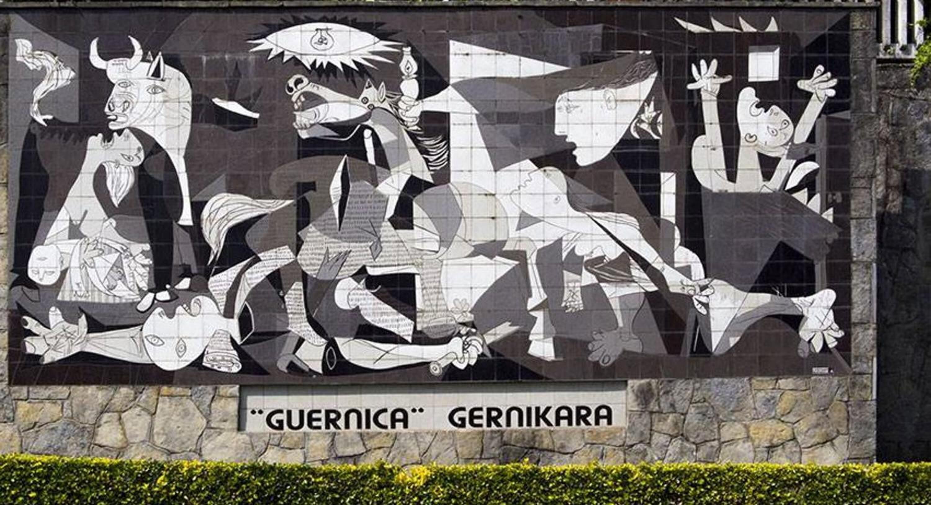 A mural with abstract figures and the text 'GUERNICA GERNIKARA' on a stone wall.