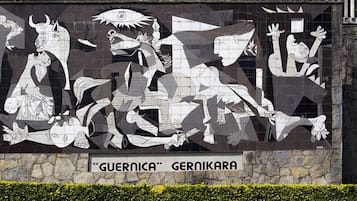 A mural with abstract figures and the text 'GUERNICA GERNIKARA' on a stone wall.