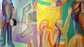 Une peinture abstraite aux couleurs vives, représentant diverses figures et formes humaines.