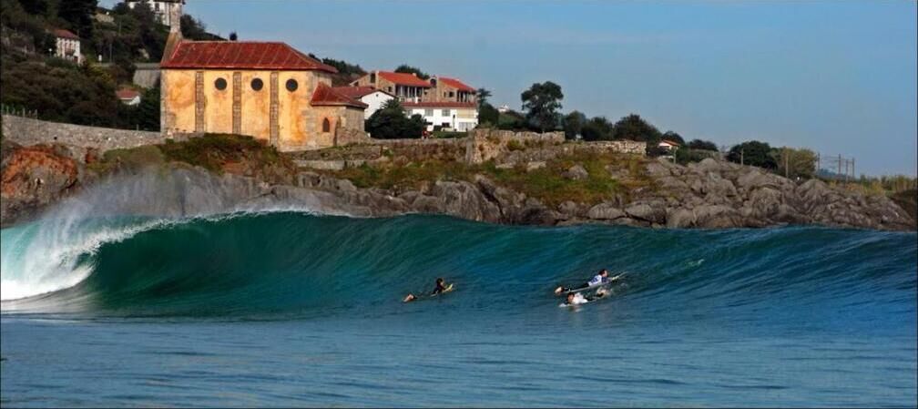 A coastal scene with a building and waves.