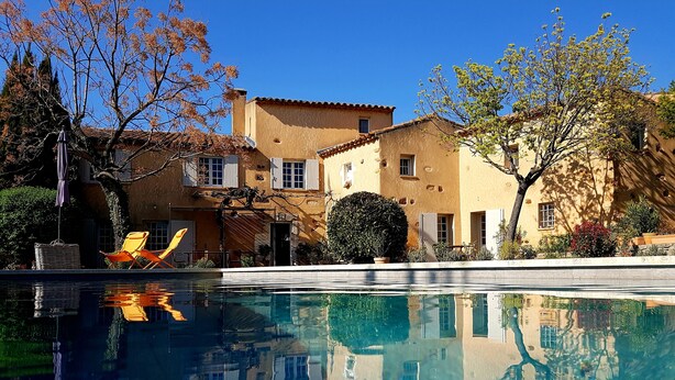 A pool with clear water reflecting buildings and trees. - Mas Roussillon (Roussillon)