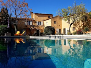 A pool with clear water reflecting buildings and trees. - Mas Roussillon (Roussillon)