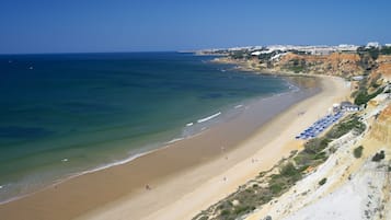 En la playa, playa de arena blanca, camastros y sombrillas