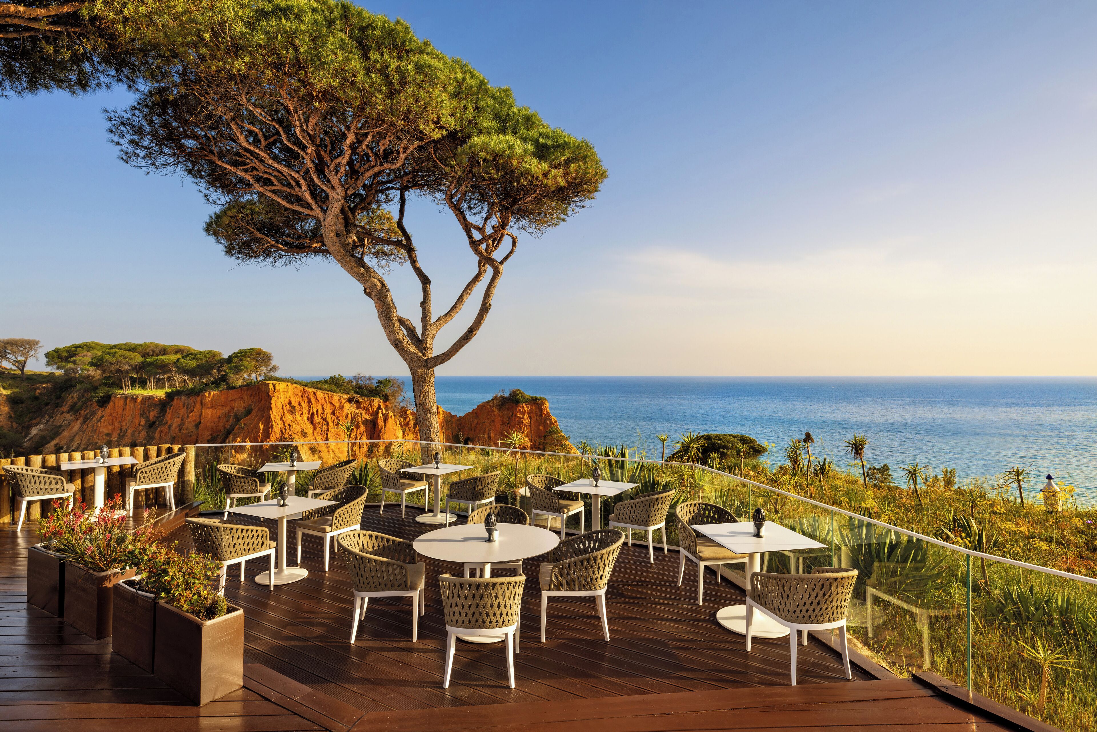 A deck with outdoor seating, overlooking a coastal landscape.