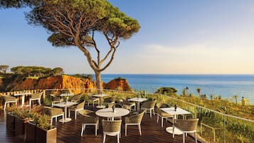 A deck with outdoor seating, overlooking a coastal landscape.