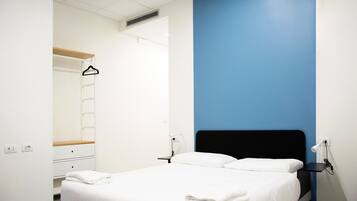 Ein Schlafzimmer mit Bett, Nachttischen, einem Kleiderschrank und einem Spiegel.