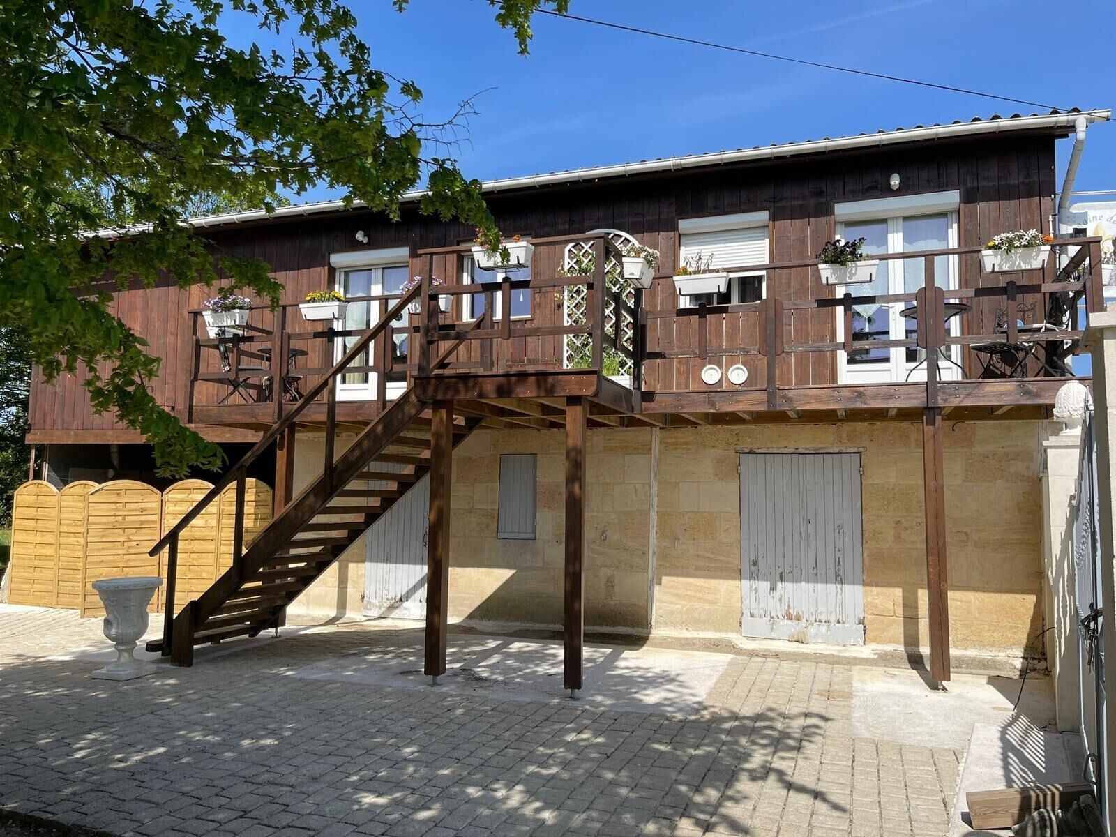 Un edificio de madera de dos pisos con una escalera de madera que conduce a un balcón.