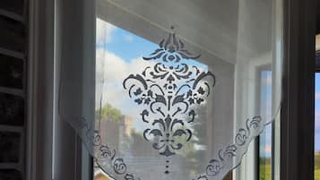 Ein Fenster mit einem dekorativen Vorhang mit aufwendiger Musterung.