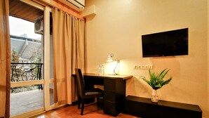 A room with a desk, chair, TV, and a potted plant. - Hotel Toma's House (Tbilisi)