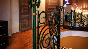 A staircase with ornate metal railings and wooden doors. - Hotel Toma's House (Tbilisi)