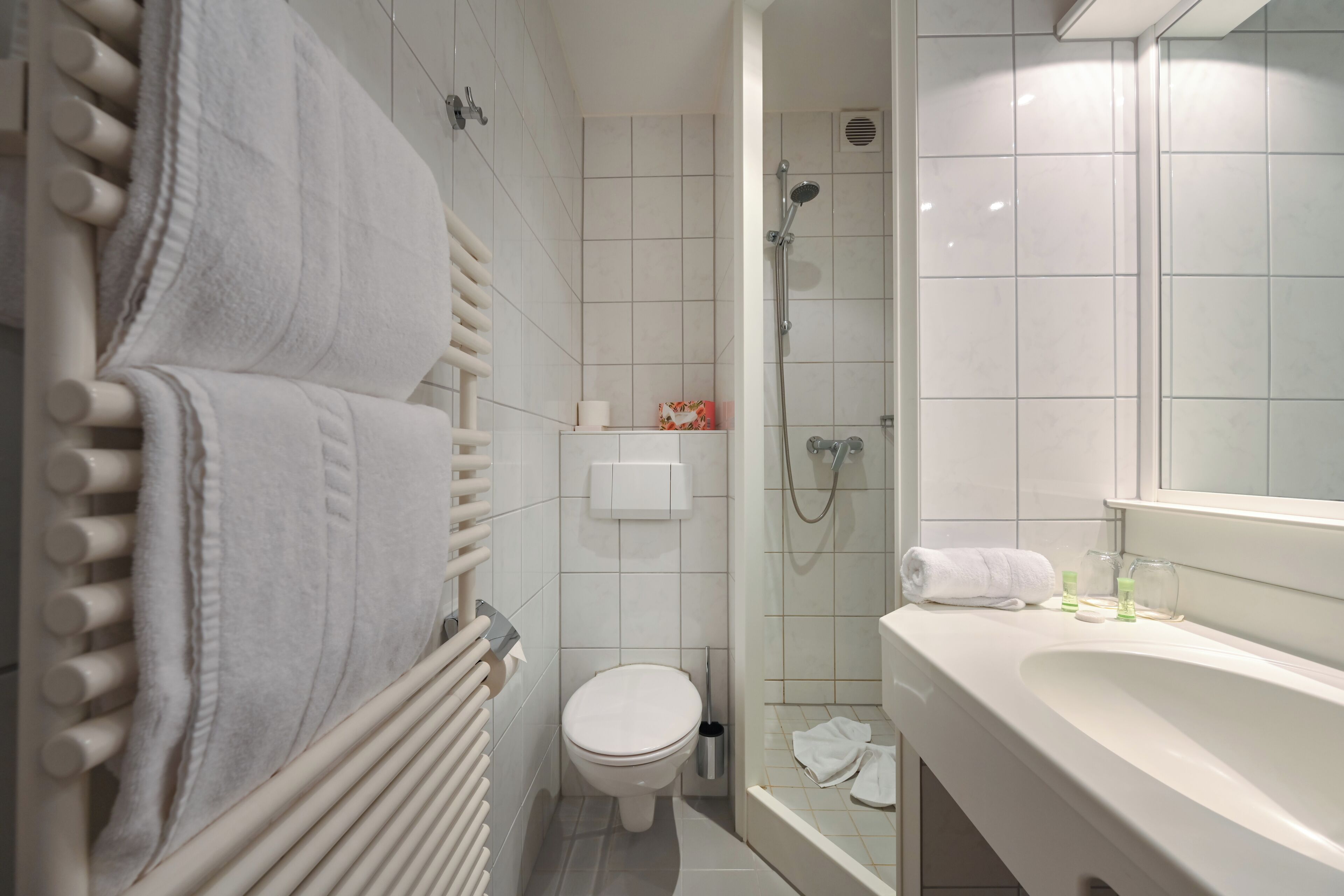 Un baño moderno con inodoro, ducha y lavamanos.