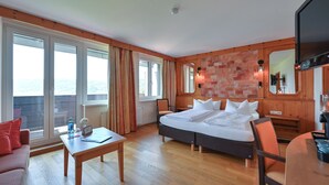 A hotel room with a large bed, a desk, a chair, and a TV. - Rothenfels Panorama Hotel (Immenstadt im Allgaeu)