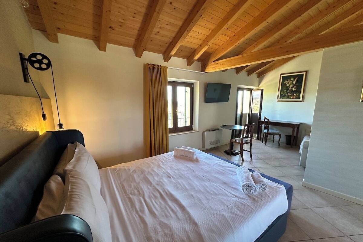 A bedroom with a bed, a desk, and a chair.
