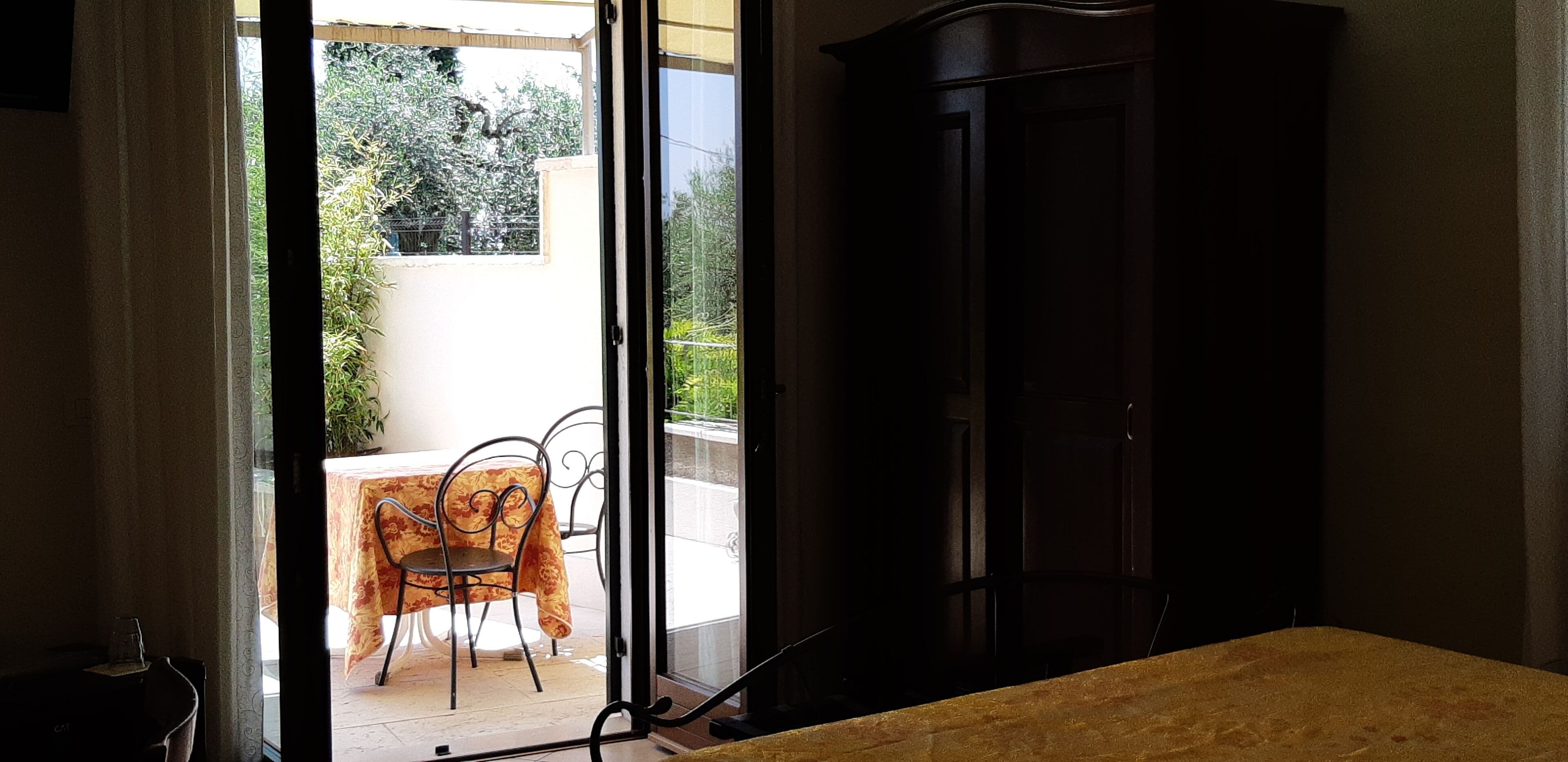 A room with a sliding glass door leading to an outdoor patio with a table and chairs.