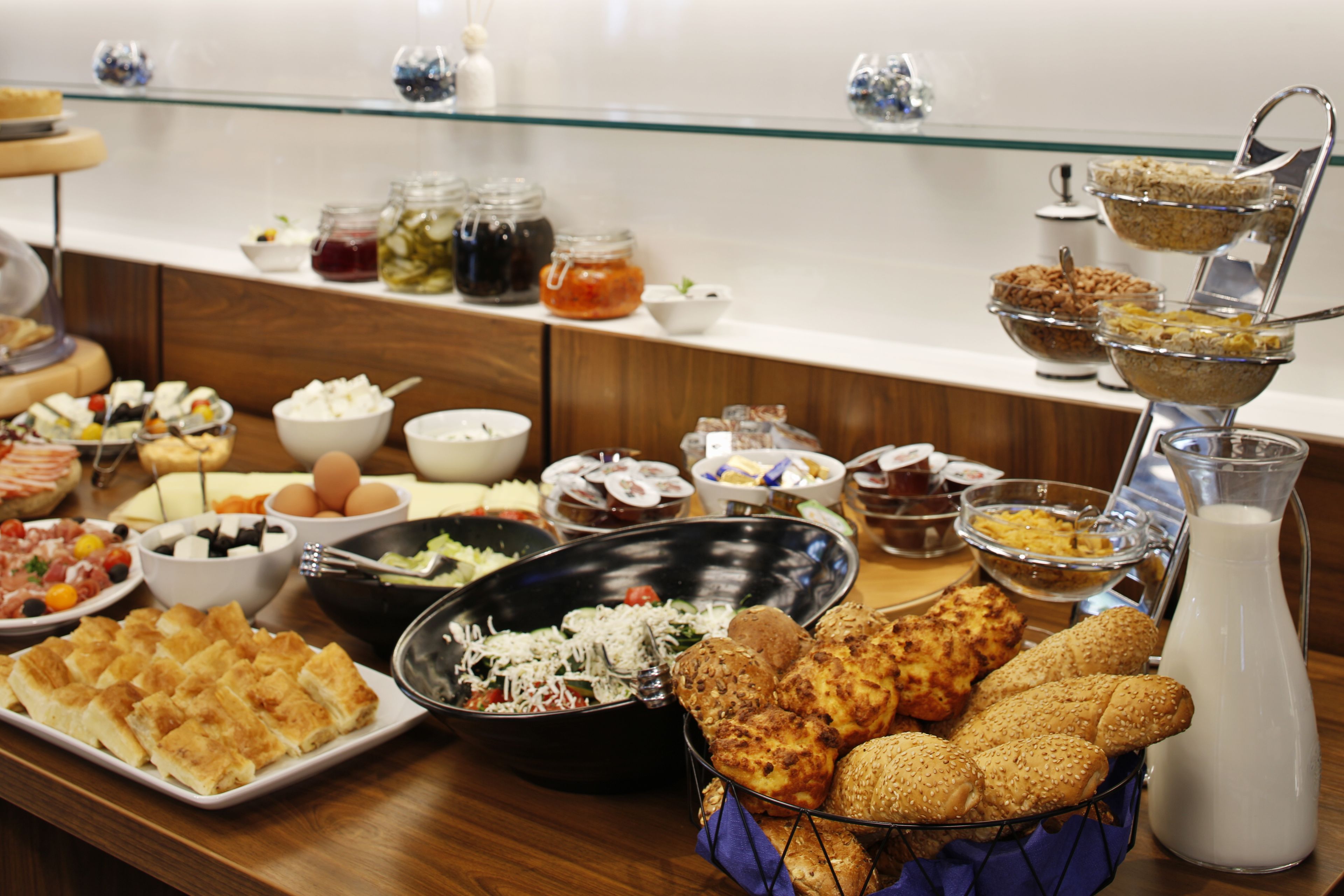 A buffet with various food items including bread, salads, and dairy products.