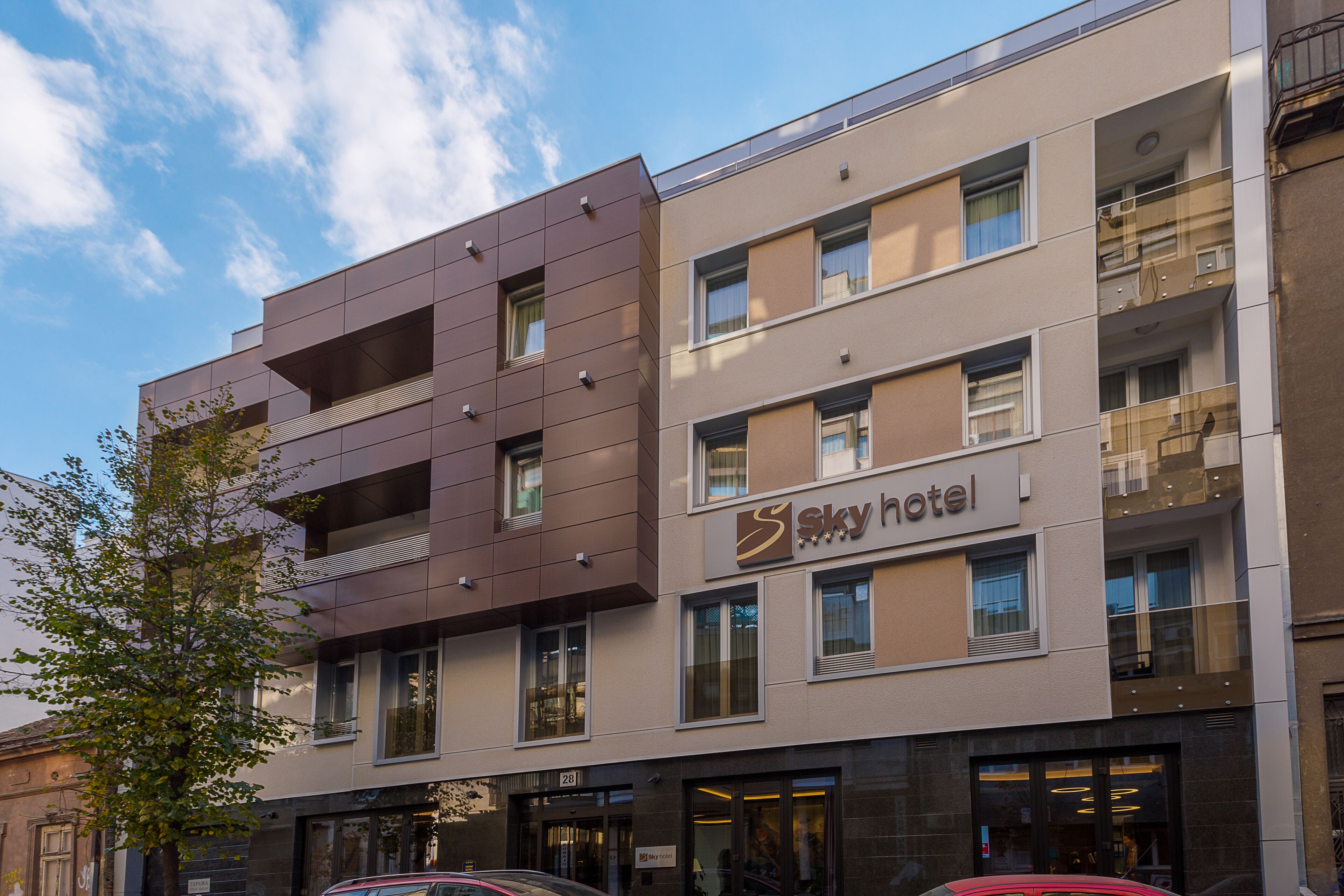 A modern hotel building with a sign reading "Sky Hotel."