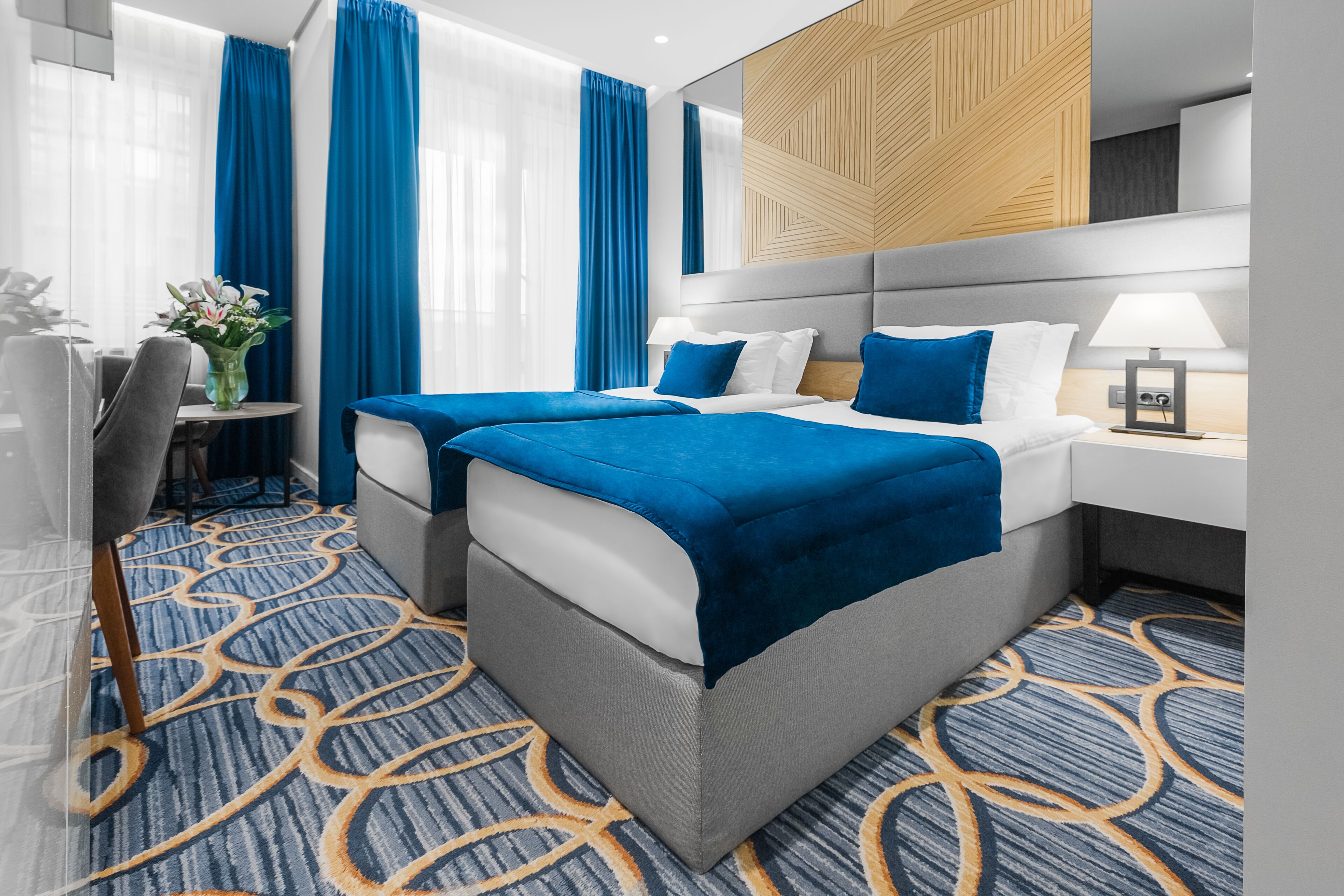 Une chambre d’hôtel avec deux lits, un bureau et une chaise.