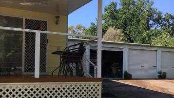 A house with a covered porch, a garage, and a bird feeder on the lawn.