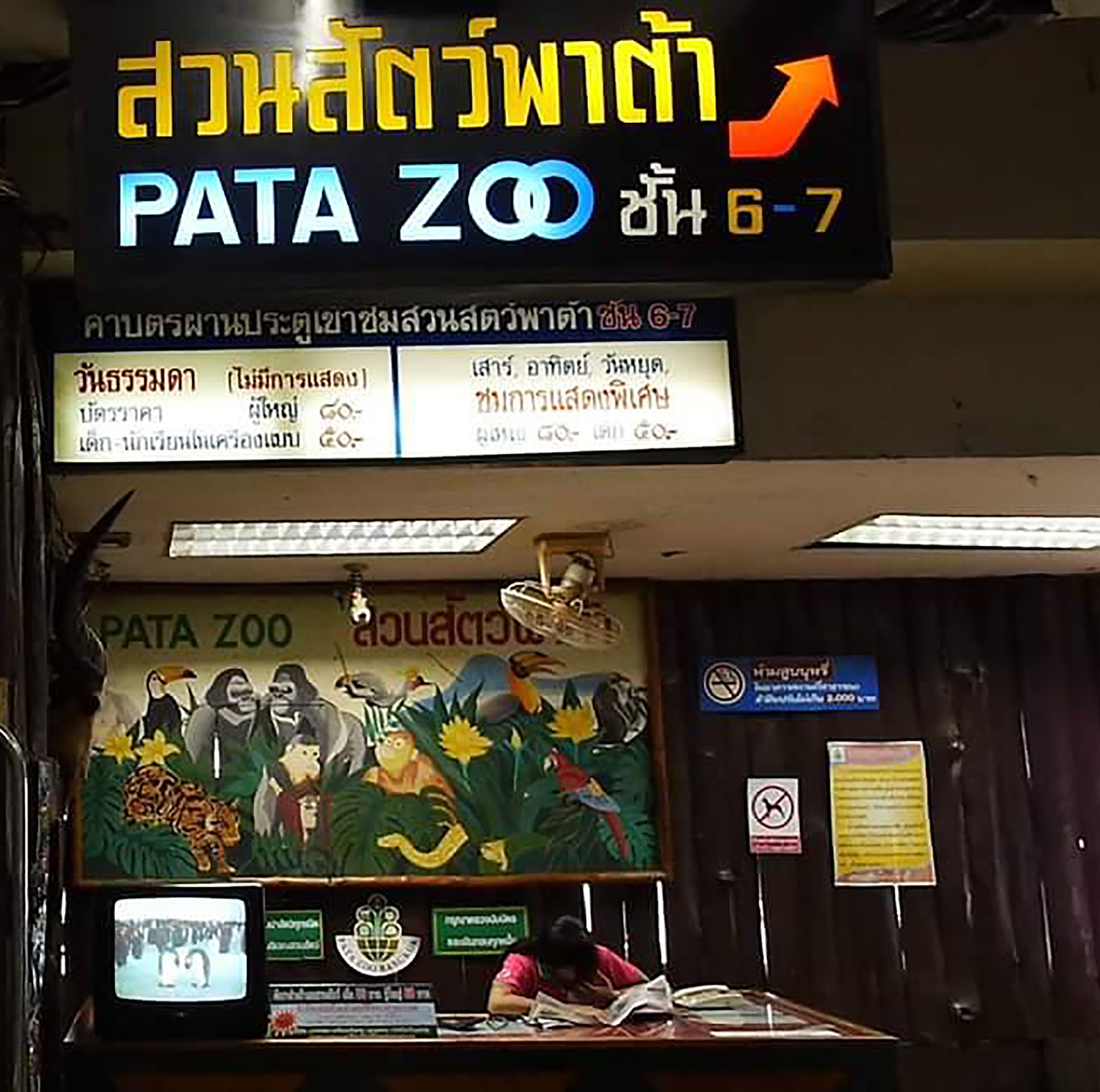 A PATA ZOO entrance with a signboard, a mural of animals, and a ticket counter.