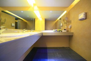 A modern bathroom with dual sinks, a large mirror, and a towel rack. - Tuk Tuk Hostel (Bangkok)