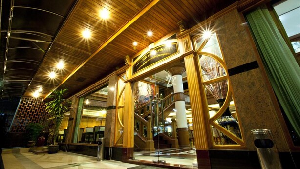 A hotel lobby with a grand staircase, large windows, and a modern ceiling design. - Zaza Hotel (Samut Prakan)