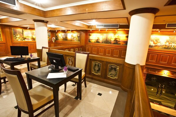 Un hall de hotel con paneles de madera, una recepción y un amplio ventanal con vista a una piscina.