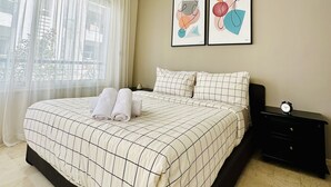 A hotel room with a large bed, a nightstand, a lamp, and two framed artworks on the wall. - La Perle de Gauthier  by StayInMorocco (Casablanca)